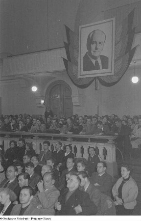 Publikum während der Eröffnungsrede der Dritten Verlegerkonferenz, im Hintergrund ein überlebensgroßes Bildnis Wilhelm Piecks