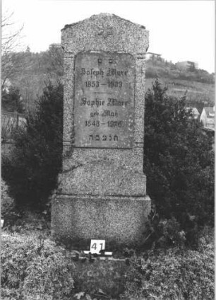 Grabstein 41 (Index: 99805048) Material: geschliffener heller Granit ?? Maße HxBxT: 178x65x20 cm Beschreibung: Stele auf Sockel mit Dreiecksgiebel; Inschriftentafel rechteckig Symbolik: sechszackiger Stern Besonderheit: Doppelgrab für Eheleute: Grabstein 41