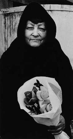 Alte Frau mit Papierblumenstrauß