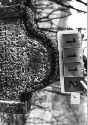Grabstein 1112 (Index: 99753265) Material: Sandstein Zustand: stark verwitt/großer Textverlust Maße HxBxT: 80x64x10 cm Beschreibung: Stele, eingezogener Rundbogenabschluß, Schriftfeld eingetieft: Grabstein 1112A
