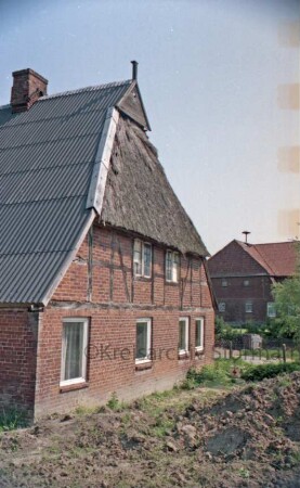 Freestot 10: Bauernhaus: Teilansicht: Giebelseite Wohntrakt: Blechdach, an Giebel noch Reetdach