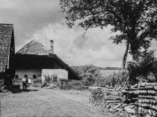 Bauernhaus : Weg zu einem Bauernhaus, rechts Holzstapel