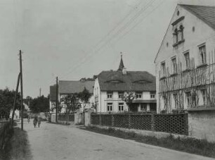 Straßenansicht mit Gehöften und Turm der Dorfkirche