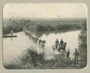 Feldübung: Karl Tuttmann, Oberleutnant in Begleitung von vier Offizieren zu Pferd, Soldaten marschieren durch einen Fluss, im Hintergrund zuschauende Kinder