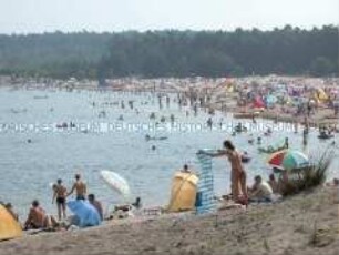 Blick auf einen See mit badenden Menschen (Altersgruppe 14-17)