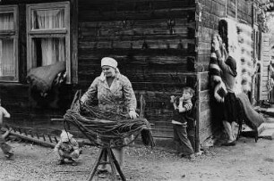 Herstellung (Frau beim Spannen von Wolle) und Verkauf von Wolldecken