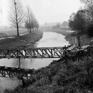 Trave: Spannbetonbrücke für Fußgänger und Viehtrieb: Bau: vorn erste Gerüste: dahinter Traveniederung mit Baumreihen und Wiesen