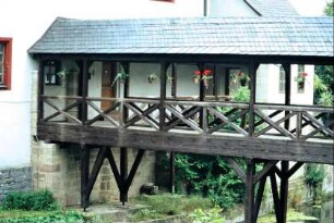 überdachte Holzbrücke über den Wassergraben des Schlosses