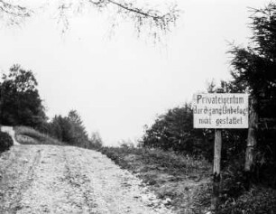 Schotterweg mit Hinweisschild
