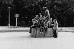 Denkmal für Käthe Kollwitz : Berlin-Prenzlauer Berg, Kollwitzplatz. Kinder und Jugendliche auf dem Sockel des Denkmals für die Bildhauerin Käthe Kollwitz (1958; G. Seitz)