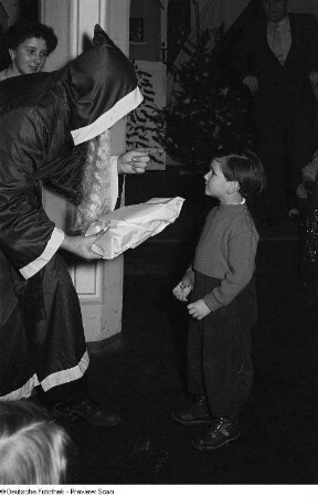 Weihnachtsmann beim Überreichen von Geschenken an Kinder auf der Weihnachtsfeier des VEB Kartographie
