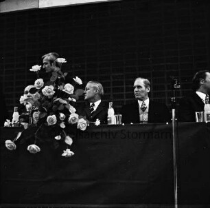 CDU: Wahlveranstaltung zur Landtagswahl 1974: Stormarnhalle Bad Oldesloe: N.N., Ministerpräsident Gerhard Stoltenberg, Karl Carstens und weitere Teilnehmer auf dem Podium: vorn links Blumenschmuck, rechts Mikrofon: 10. März 1974