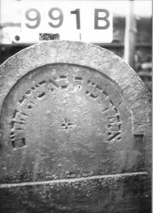 Grabstein 991 (Index: 99630494) Material: Sandstein Zustand: stark abgeblättert-Stele Maße HxBxT: 108x48x6 cm Beschreibung: Stele mit eingezogenem Rundbogenabschluß Besonderheit: Zitat Psalm 116, 9: Grabstein 991B