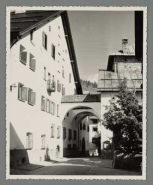 Gasse mit Rundbögen zwischen Hausfassaden in Zuoz