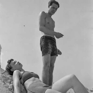 Mann steht am Strand, daneben liegt Elisabeth Gremmler