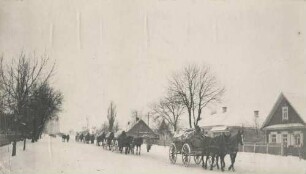 Deutsche Truppen im Pferdewagenzug im Winter durch ein weissrussisches Dorf fahrend