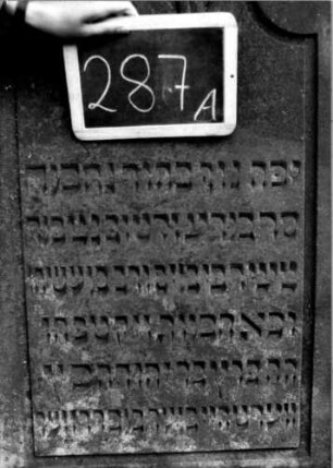 Grabstein 287 (Index: 100112042) Material: Sandstein Zustand: gut Maße HxBxT: 193x72x31 cm Beschreibung: Stele, profilierter Sockel, giebelartiger Abschluß mit Verdachung, rechteckiges Schriftfeld eingetieft, oben mit rund eingezogenen Ecken Symbolik: segnende Hände, geknickte Rose: Grabstein 287A