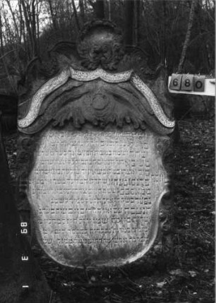 Grabstein 680 (Index: 99752399) Material: Sandstein Zustand: verwittert mit Textverlust Maße HxBxT: 182x112x12 cm Beschreibung: Stele, geschweifter Abschluß, ovales Schriftfeld Symbolik: Levitenkanne, Ranken, Blätter, Schriftband: Grabstein 680