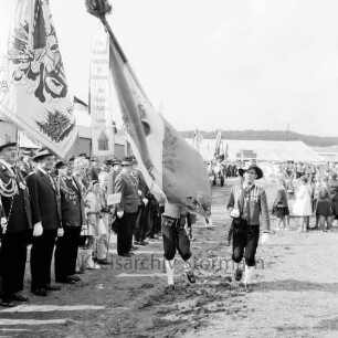 Schützenfest: Veranstalter Schützenverein Reinfeld und Umgebung von 1954 e.V.: Festplatz an der Ahrensböker Straße: Fahnenträger der Tiroler Schützen der Schützenkompanie Wilten (bei Innsbruck) schreiten an Front der mit Fahne angetretenen Schützen vorbei: hinten rechts Zuschauer: im Hintergrund Festzelt, 9. September 1962