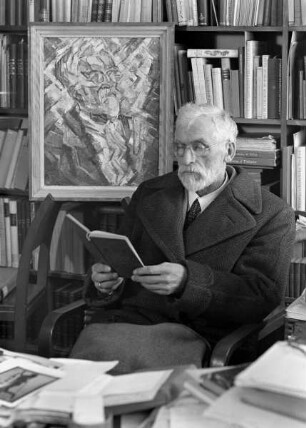 Porträt des lesenden Richard Hamann in seinem Arbeitszimmer im Kunsthistorischen Seminar der Philipps-Universität Marburg vor seinem Bildnis von Reinhard Schmidthagen