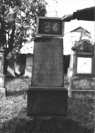 Grabstein 36 (Index: 100112287) Material: Kalkstein (?) Zustand: gut Maße HxBxT: 110x28x22 cm Beschreibung: Obelisk, getreppter Sockel, unterer Sockelteil rusticaartig: Grabstein 36