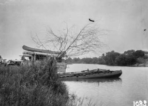 Am Flussufer : Blick auf eine Flusslandschaft mit Floß und Expeditionsfahrzeug
