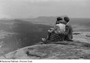 Roger und Renate Rössing, an einem Abhang sitzend