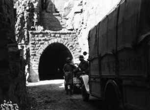 Am Tunnel : Expeditionsmitglieder mit Automobilen vor einem Tunnel