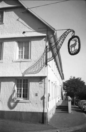St. Georgen (Schwarzwald): Gasse mit Aushängeschild "Hirsch" wirft Schatten