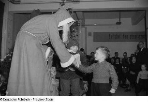 Weihnachtsmann, einem kleinen Jungen ein Geschenk überreichend
