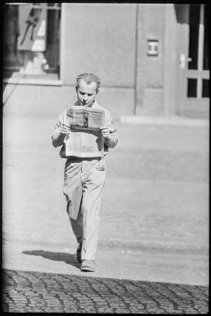 Zeitungsleser auf Straße, 1960er Jahre. SW-Foto © Kurt Schwarz.