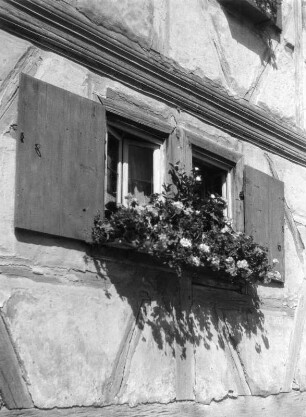 Hellmitzheim. Blumenkasten an einem Fensterpaar einer Bauernhausfassade