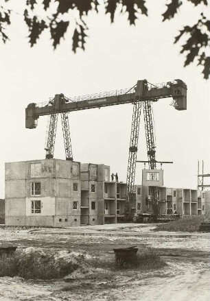 Hoyerswerda-Neustadt. Wohnungsbaustelle, Bautzener Allee (?) : Hoyerswerda-Neustadt. Wohnungsbaustelle, Bautzener Allee (?). Montage von Wohnhäusern in Plattenbauweise mit Portalkran (etwa 1959; VEB Kranbau Eberswalde)