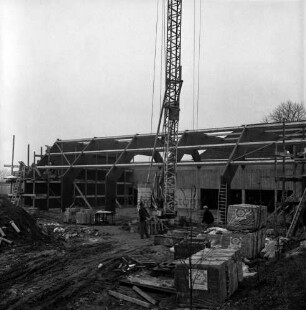 Tremsbüttel-Dorf: Gemeindezentrum: Mehrzweckhalle im Bau: Blick von außen auf Dachkonstruktion aus Holz-Leimbinder: Kran: davor Arbeiter: im Vordergrund Baumaterial