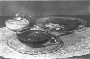 Stillleben mit gläsernem Kuchenteller, Teetasse und Zuckerschale auf Spitzendeckchen