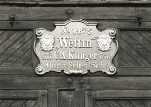 Dreschmaschine : Dreschmaschine. Holz, Eisen. nach 1854. Detail: Firmenschild. Niesky-Ödernitz, Helmut-Just-Straße 37, Gehöft