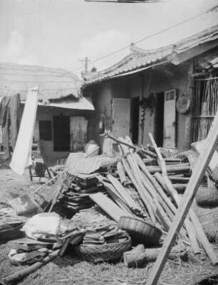 Dorf Kozai in Nordkorea : Koreanischer Hof. Ansicht mit gestapeltem Hausrat und Baumaterial