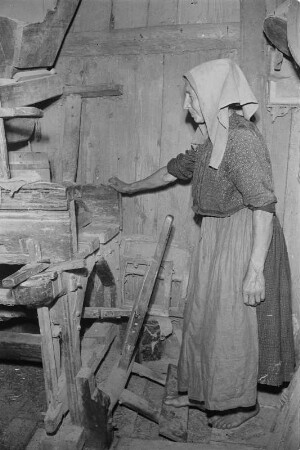 In der Graupenmühle in Tätschwitz. Frau in Hoyerswerdaer Arbeitstracht bei der Verarbeitung von Graupen. : Holanska kruparka při dźěle w Ptačecach.