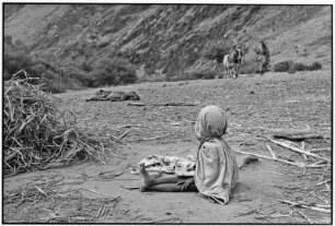 Udaipur. Sitzendes Kind auf einem abgeerntetem Feld