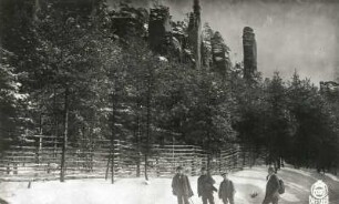 Böhmische Schweiz (České Švýcarsko), Eiland (Ostrov). Wandergruppe auf der Eilander Straße. Blick nach Südosten gegen Empornadel (Vztyčená jehla) und Emporturm (Vztyčená věž)