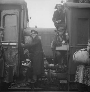 Leipzig. Hauptbahnhof. Überfüllter Personenzug ("Hamsterzug") mit Reisenden auf Puffern