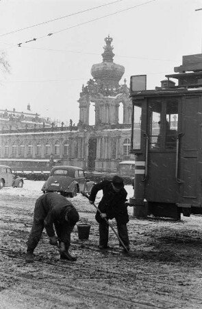 Dresden. Reportage "Was kostet der Schnee?" Straßenbahner beim Freiräumen einer Weiche am Postplatz/Ostra-Allee, im Mittelgrund Zwinger mit Kronentor
