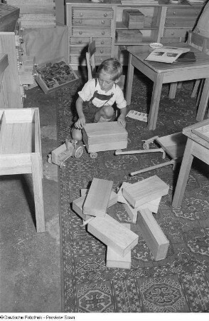Ein Junge spielt mit Holzspielzeug, Herbstmesse 1953