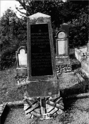Grabstein 25 (Index: 99802057) Material: Sandstein mit schwarzer Marmorplatte Zustand: leicht verwittert Maße HxBxT: 185x57x35 cm Beschreibung: Obelisk, getreppter Sockel, Schrifttafel rechteckig Besonderheit: Doppelgrab für Eheleute: Grabstein 25