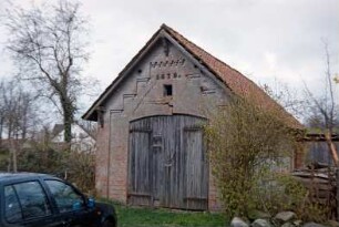 Gut Jersbek: Spritzenhaus aus Backstein: Giebelseite mit Tor, darüber Jahreszahl 1879: davor Pkw