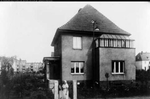 Frau vor Wohnhaus