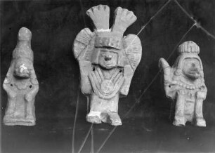 Figuren einer hockenden Gestalt mit Tiergesichtern und einer Göttin?