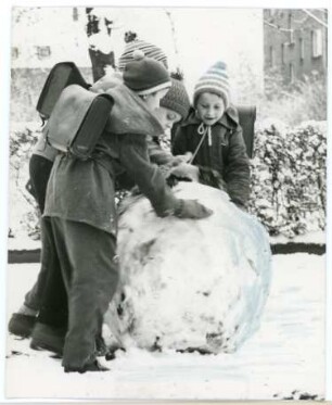 Kinder beim Schneeball bauen