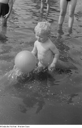 Kleiner Junge, mit einem Ball im Wasser spielend