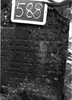 Grabstein 588 (Index: 100102454) Material: Sandstein Zustand: stark verwittert, leicht eingesunken, weitgehender Textverlust Maße HxBxT: 91x58x11 cm Beschreibung: Stele, Konvexbogenabschluss, Schriftfeld eingetieft: Grabstein 588 (Detailaufnahme)